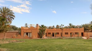Un edificio tradicional con techo plano, varias ventanas y un patio.