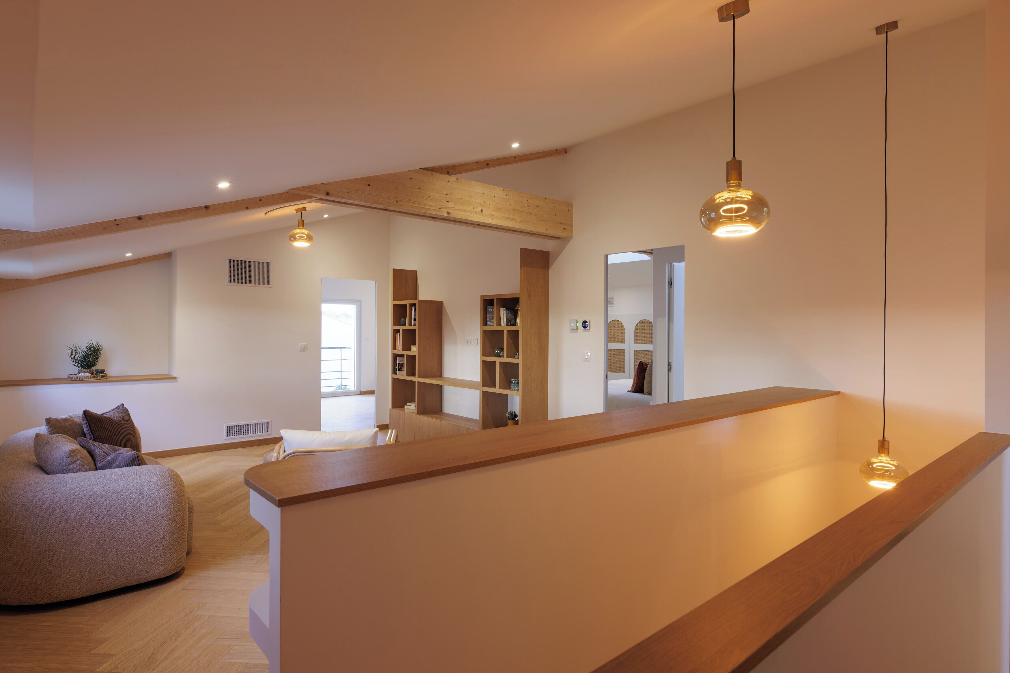 A modern interior with a wooden ceiling, a built-in bench, and a hanging light fixture.