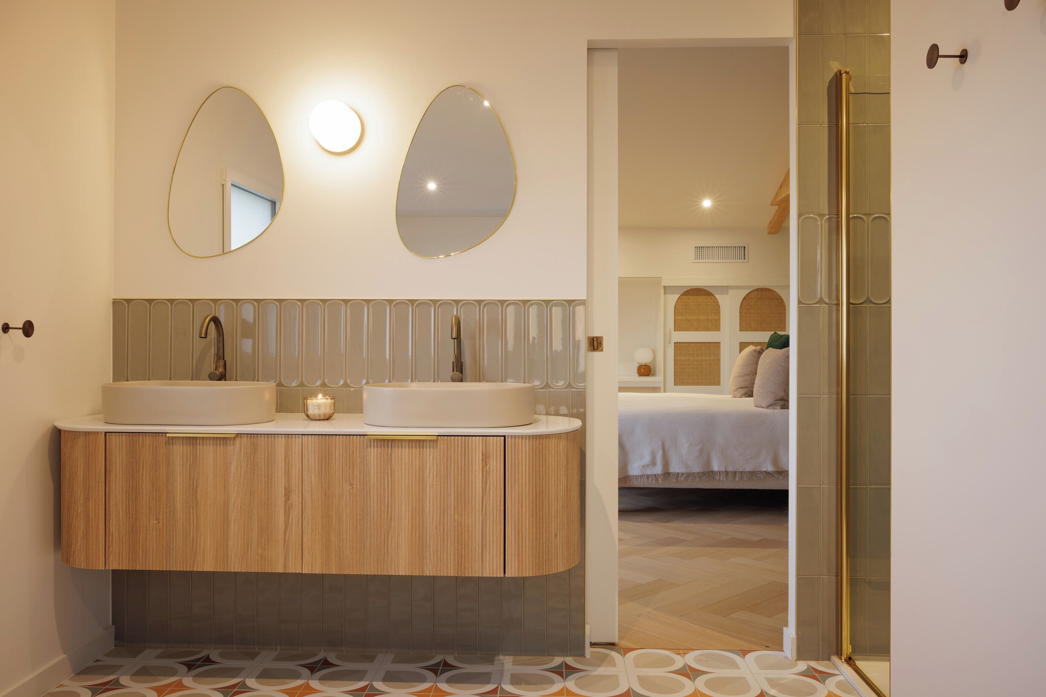 Une salle de bain moderne avec deux lavabos, un miroir et un espace douche.