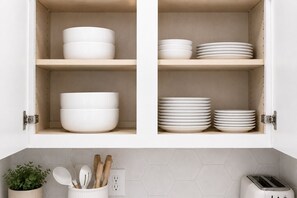 A kitchen with white cabinets, a plant, wooden utensils, and a toaster. - Designer Dream 3BR for Families & LongStays + Pool (Plano)