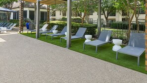 A patio area with outdoor seating and a pergola structure. - Pristine 1BR Home w/ Premium Amenities+Pool & Gym (Plano)