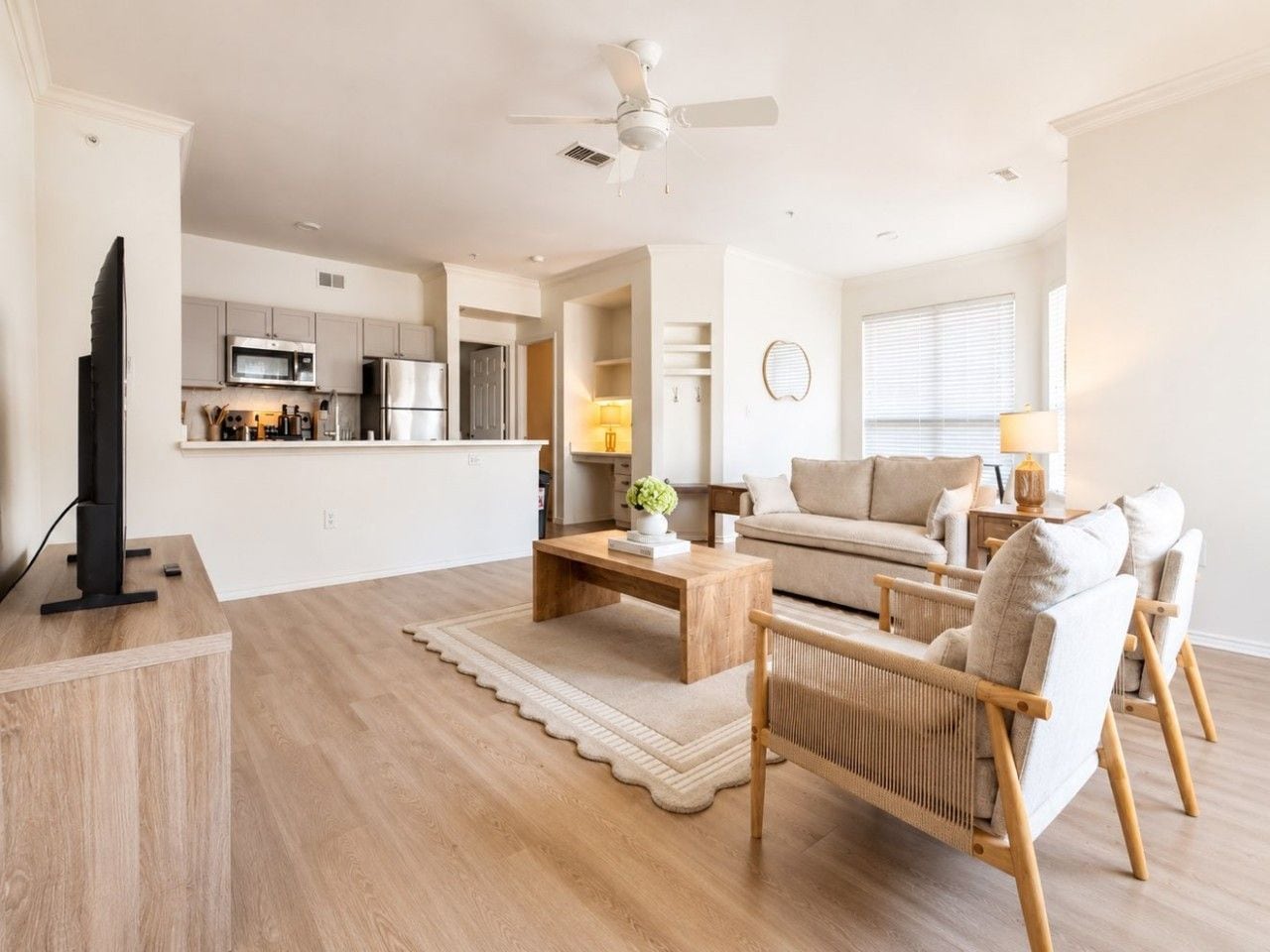 A modern living room with a flat-screen TV, a wooden coffee table, and a sofa set.