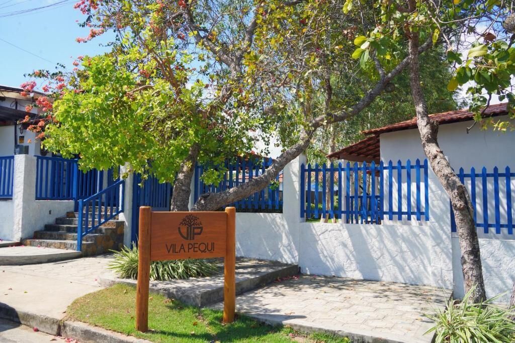 A sign with 'VILA PEQUI' and a blue fence.