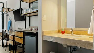 Un bagno moderno con un ampio specchio, un lavandino e un portascopevoli.