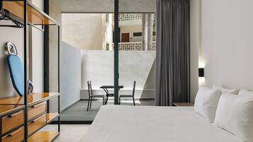 Una habitación de hotel con cama, escritorio, sillas y armario.