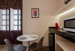 A dining area with a round table, chairs, a television, and a framed picture on the wall. - Villa Maria Teresa By Homirent (Mérida)