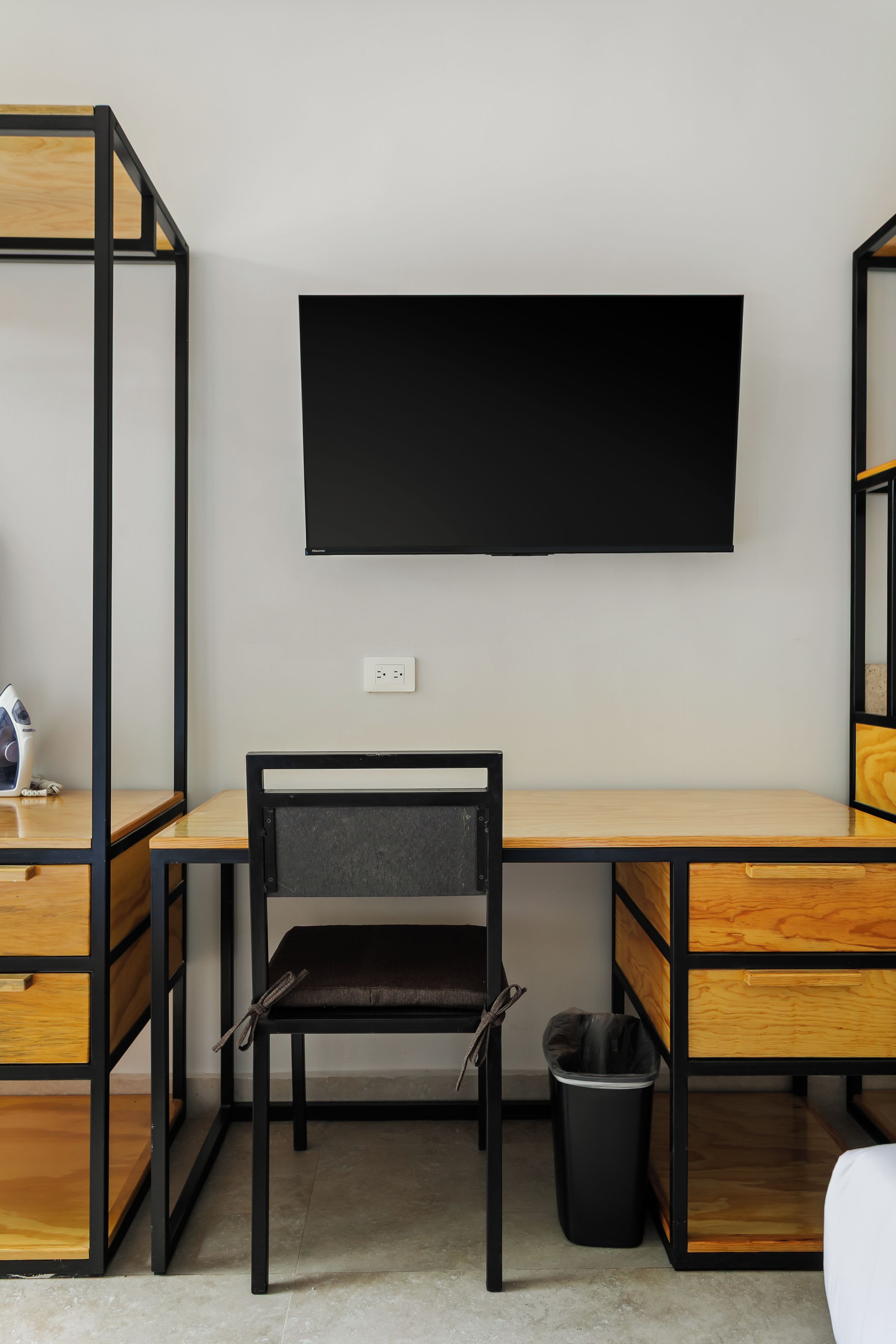 A modern workspace with a desk, chair, and a mounted television.