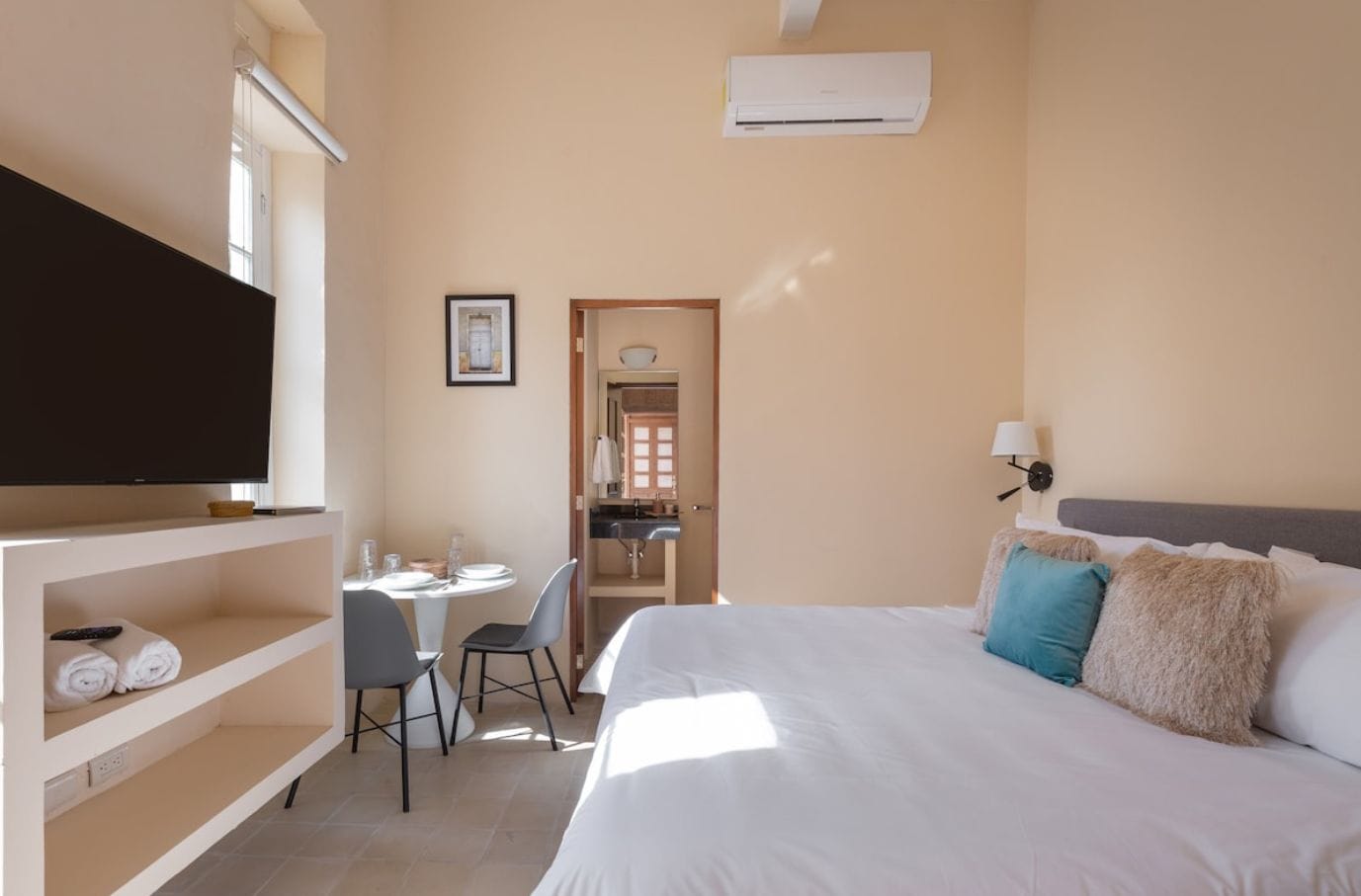 Une chambre d’hôtel avec un lit, une télévision, un bureau et une chaise.