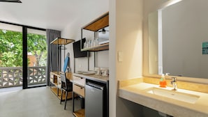 Una cocina moderna con lavavajillas integrado, una mesa de comedor de madera y un espejo grande sobre el fregadero.