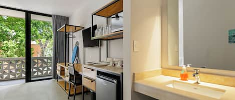 A modern kitchen with a built-in dishwasher, a wooden dining table, and a large mirror above the sink.