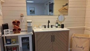 A bathroom with a sink, mirror, storage cabinet, and a small rug. - Updated Chimney Rock cabin - Views & River Sounds (Chimney Rock)