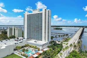 A high-rise hotel with a pool area, a marina, and a bridge in the background. - Trendy Cozy Waterfront APT - 1 bedroom 1.5 bath with a projector tv (Fort Myers)