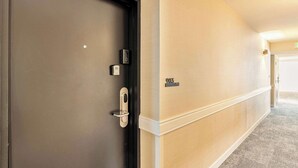Ein Hotelgang mit einer Tür, einem Wandzeichen und einem Teppichboden.