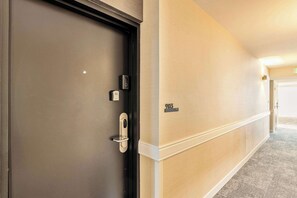 A hotel hallway with a door, a wall-mounted sign, and a carpeted floor. - High Rise 9th Floor City Views Free Pkg, Gym (Salt Lake City)
