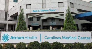 Un edificio con señalización de Atrium Health y Carolinas Medical Center, que presenta un diseño arquitectónico moderno con señalización y jardines destacados.