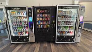 Tres máquinas expendedoras con la etiqueta 'canteen', que ofrecen diversas bebidas y aperitivos.