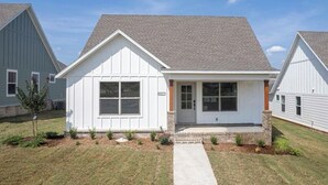 A single-story house with a gabled roof, a front porch, and a small front yard.