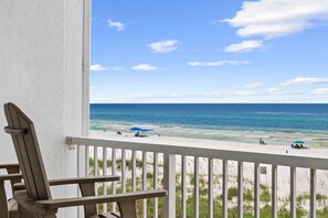 Ein Balkon mit Blick auf Strand und Meer.