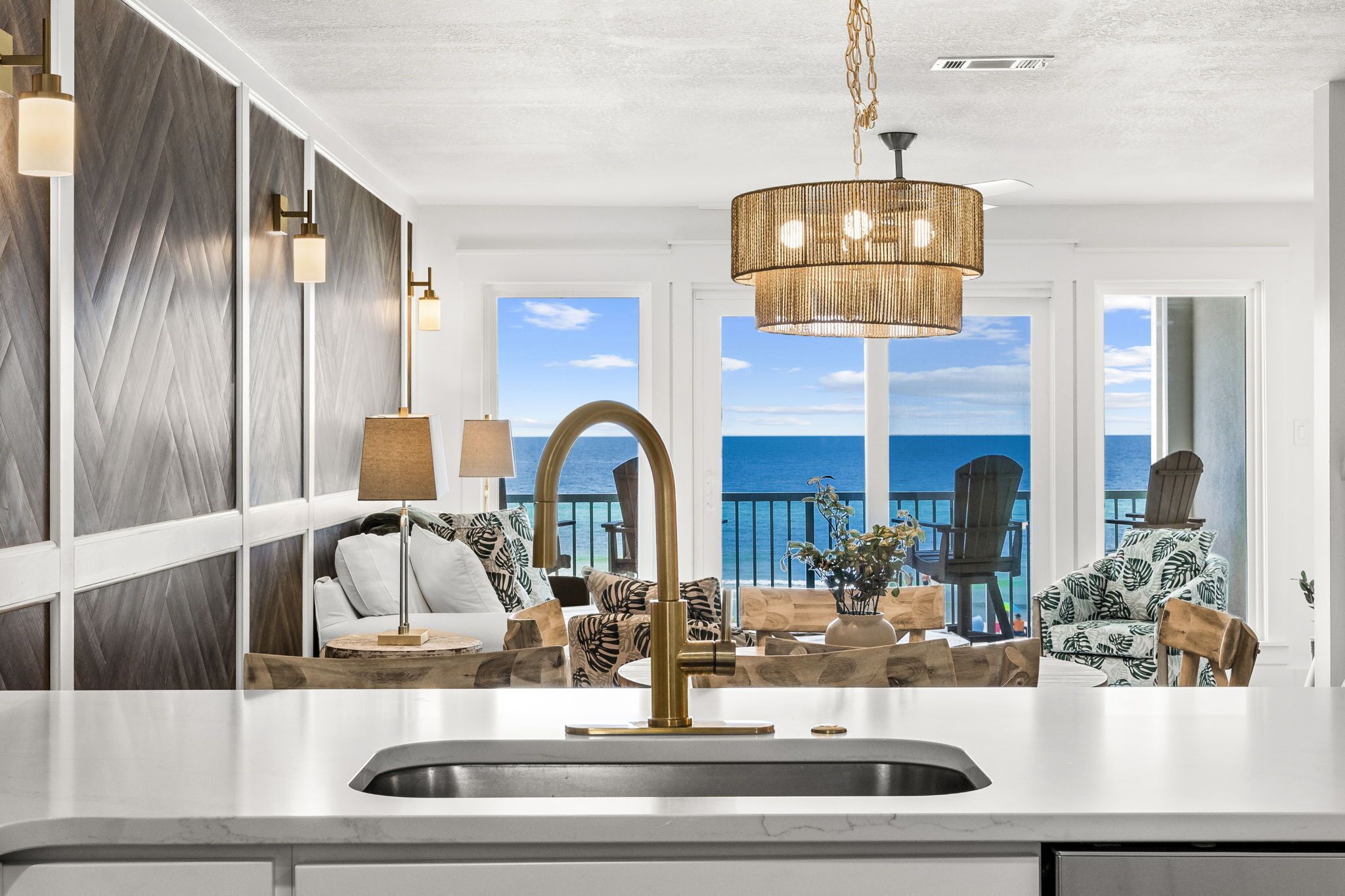 A modern kitchen with a large island, a view of the ocean, and a seating area with a view.