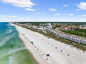 A coastal hotel with multiple buildings, a beach with umbrellas, and a clear view of the ocean. - Brand NEW Luxury Beachfront Paradise ~ Minutes to 30a! (Panama City Beach)
