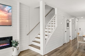 Ein modernes Interieur mit einer Treppe, einem Kamin und einem Essbereich.