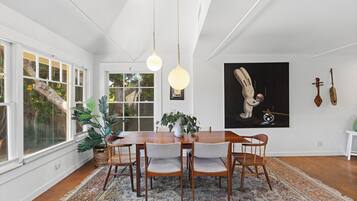 A dining area with a wooden table, chairs, and a patterned rug.
