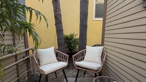A small patio area with two wicker chairs, a small table, and a potted plant. - Newly renovated, Stylish Studio Beach Bungalow a couple of blocks from the beach (Los Angeles)