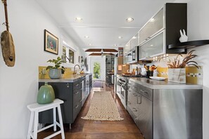 Una cocina moderna con electrodomésticos de acero inoxidable, una isla central y vistas al área de comedor.