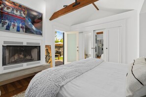 Un dormitorio con una cama grande, una chimenea y vistas al exterior.