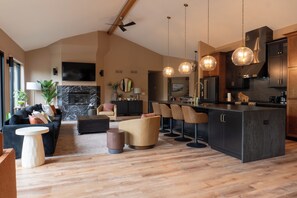 Una cocina moderna con armarios oscuros, una isla central y taburetes de bar.