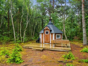 A small wooden cabin with a hexagonal window and a chimney, surrounded by a forest. - "Jooseppi" - 4.8km from the sea by Interhome (Læsø)