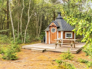 A log cabin with a hexagonal door, a chimney, and a picnic table in a forest setting. - "Jooseppi" - 4.8km from the sea by Interhome (Læsø)