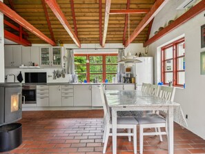 A kitchen with a central island, a stove, and a window with a view of greenery. - "Jooseppi" - 4.8km from the sea by Interhome (Læsø)