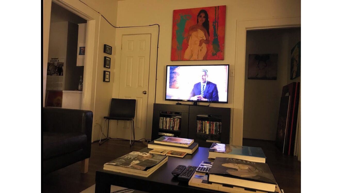 A living room with a television, books, and a coffee table.