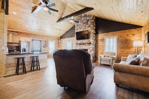 Ein gemütliches Blockhaus-Interieur mit Küche, Essbereich und Sitzgelegenheiten.