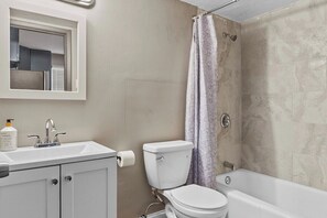 Ein Badezimmer mit Toilette, Waschbecken und Badewanne.