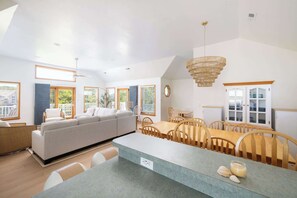 A modern kitchen with a dining area, a sofa, and a chandelier. - Walk to Beach w/ Private Pool in the Heart of Duck (Duck)