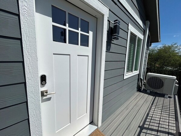 A house with a white front door, a small porch, and an air conditioning unit. - Cozy Cabin Near Marina | Boating & Hiking | Perfect Getaway (Coeur d'Alene)