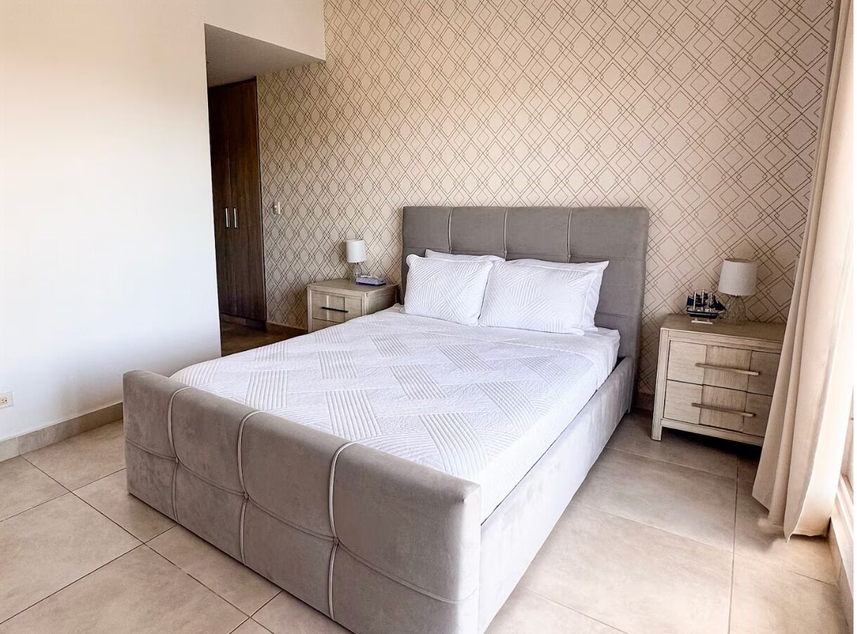 A bedroom with a bed, nightstands, and a wardrobe.