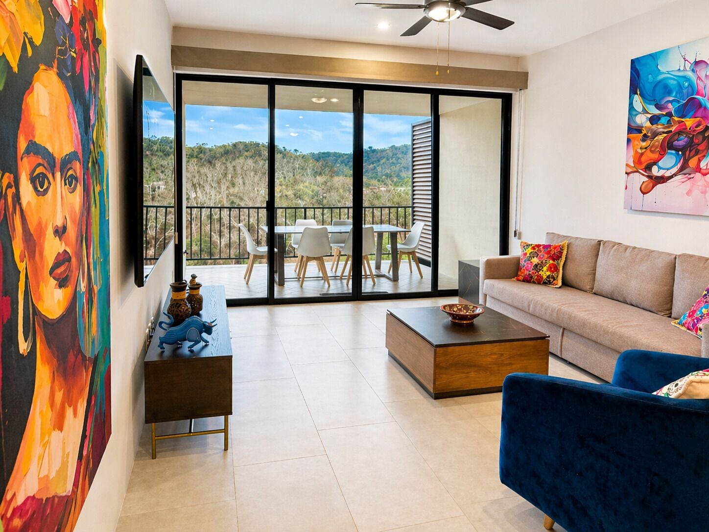 Colorful living with Friday artwork and view of the Sierra Madre mountains. Living room has both sheer and blackout manual shades. 