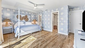 A bedroom with a bed, bedside tables, a ceiling fan, and a wardrobe.
