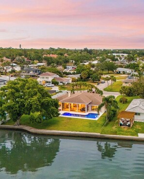 A residential area with houses, a swimming pool, and a body of water. - Grand Oak at Seaview | Waterfront + Private Heated Pool (Sarasota)