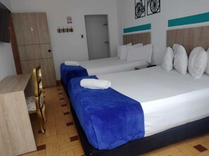 A hotel room with two beds, a desk, and a wardrobe.