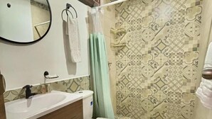 A bathroom with a sink, toilet, and shower curtain. - hotel boutique casa vecchia  (Cali)