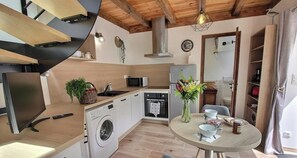 Eine moderne Küche mit Waschmaschine, Mikrowelle und Essbereich, gedeckt für zwei Personen.
