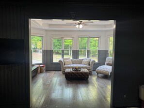 A room with a large window, a ceiling fan, and a wooden floor. - Atlanta Luxury Estate, Pool, Sauna, Theatre, Tennis Court - World Cup Ready (Atlanta)