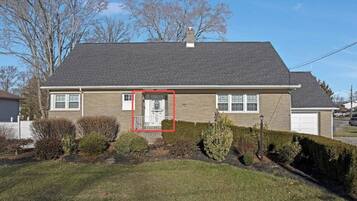 A single-story house with a front door, a garage, and a well-maintained lawn.