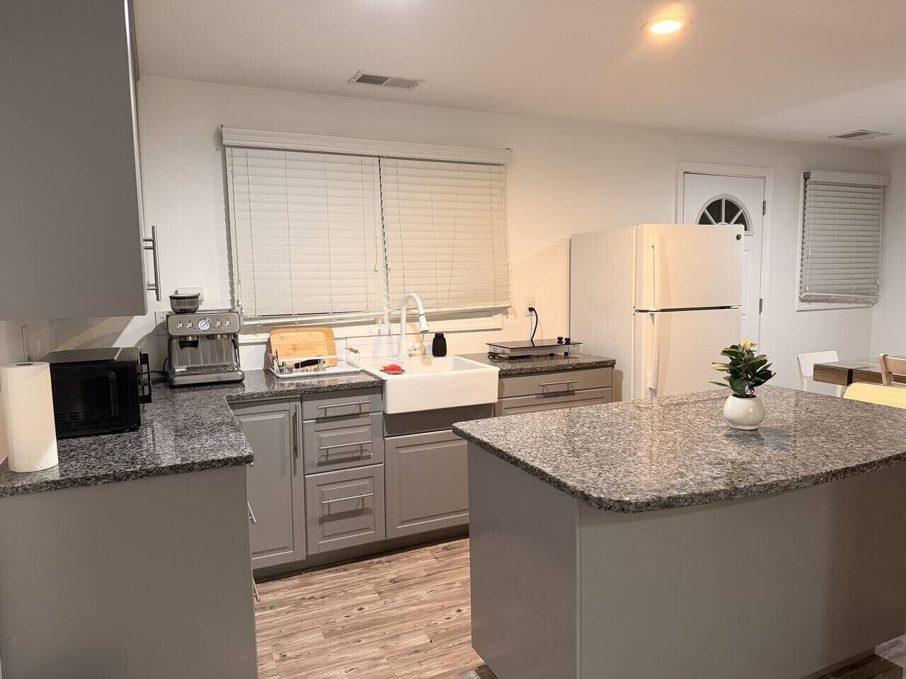 A modern kitchen with granite countertops, a built-in oven, and a sink.