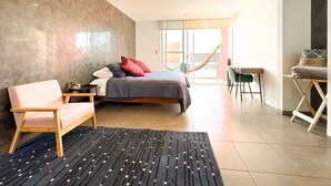 Une chambre à coucher moderne avec un lit, une chaise, un bureau et un hamac.