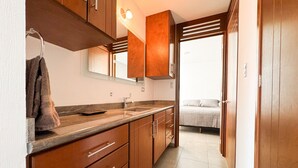 Une cuisine moderne avec des meubles en bois, un évier et une serviette accrochée au mur.